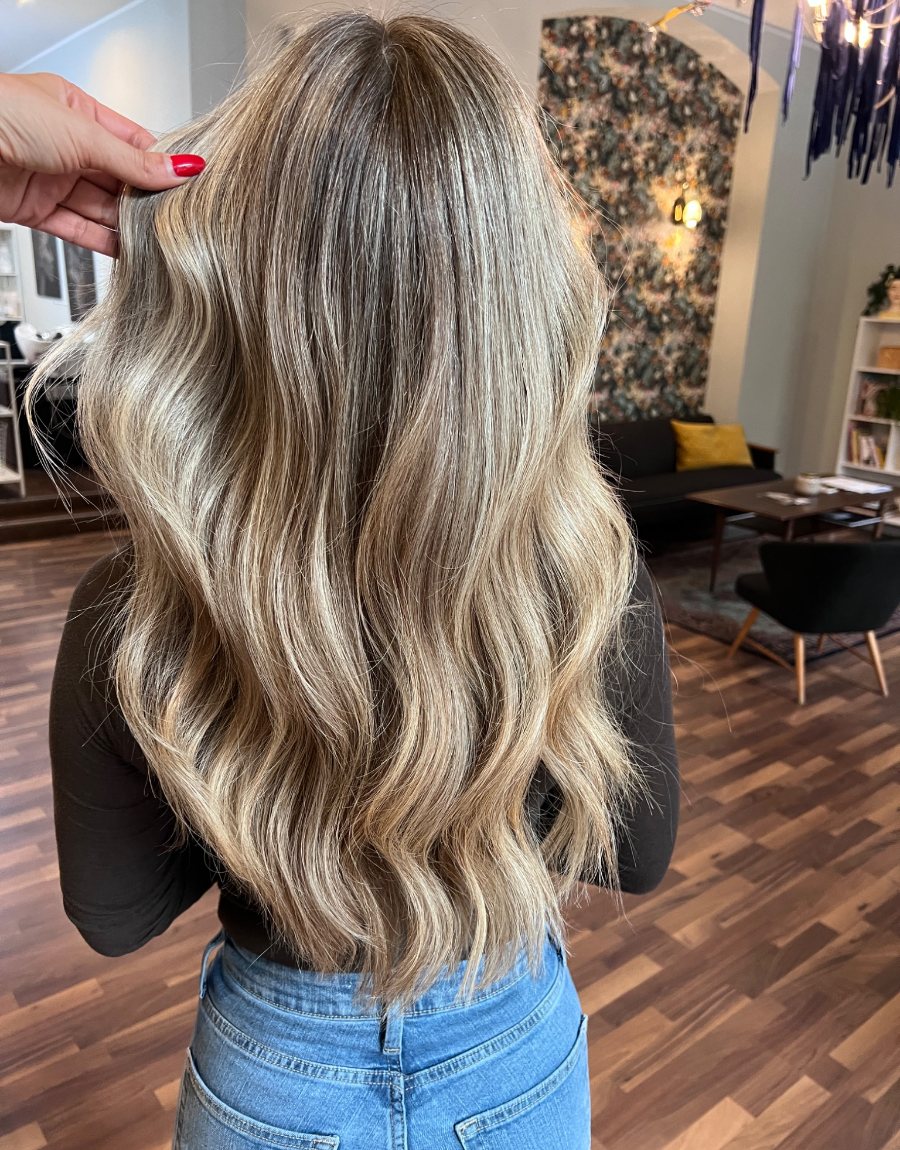 Blonde Wellen mit feinen Highlights und viel Glanz im Salon